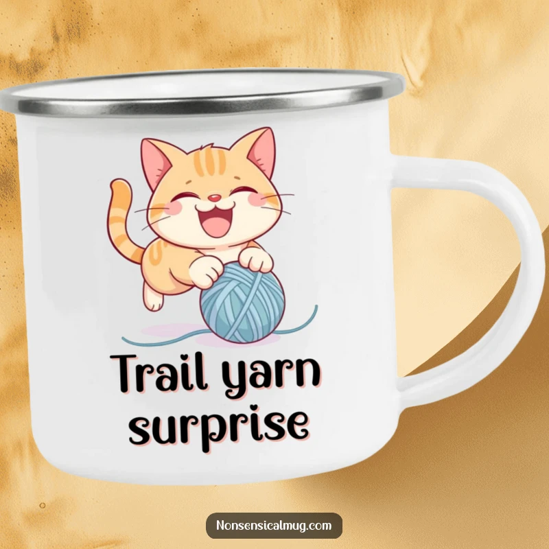 Funny camping mug featuring a mischievous cat character pouncing on a yarn ball, designed for outdoor fun and laughter.