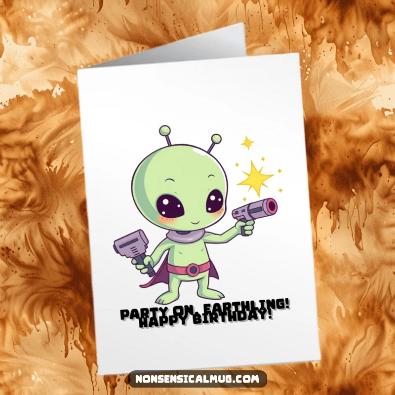 Funny Free Printable birthday card: a cute kawaii alien with a ray gun shooting dazzling sparkles, wishing happy birthday.