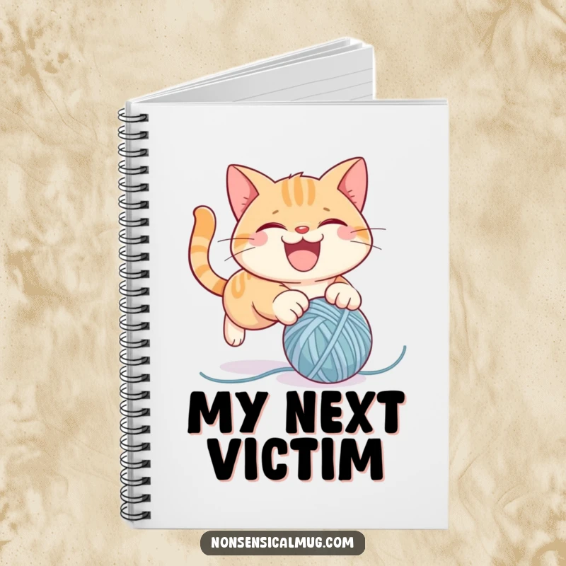 Funny notebook featuring a mischievous cat character playfully pouncing on a ball of yarn, perfect for journaling and note-taking.