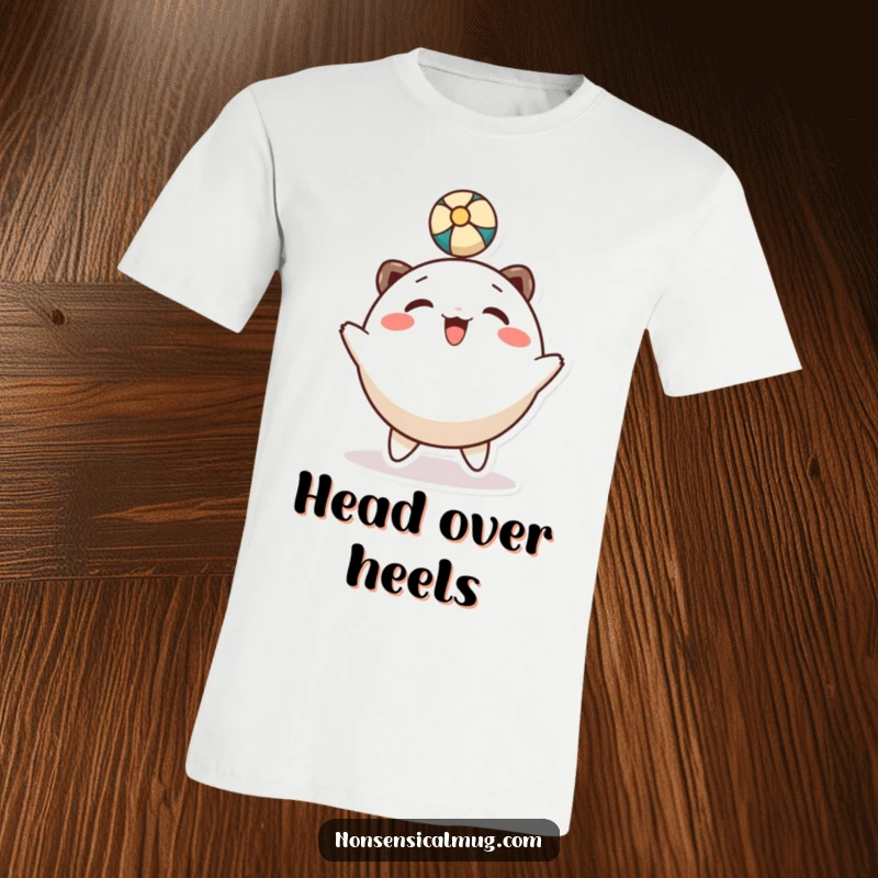 Funny T-Shirt: A smiling, round character is joyfully bouncing a ball with its head in a playful manner.