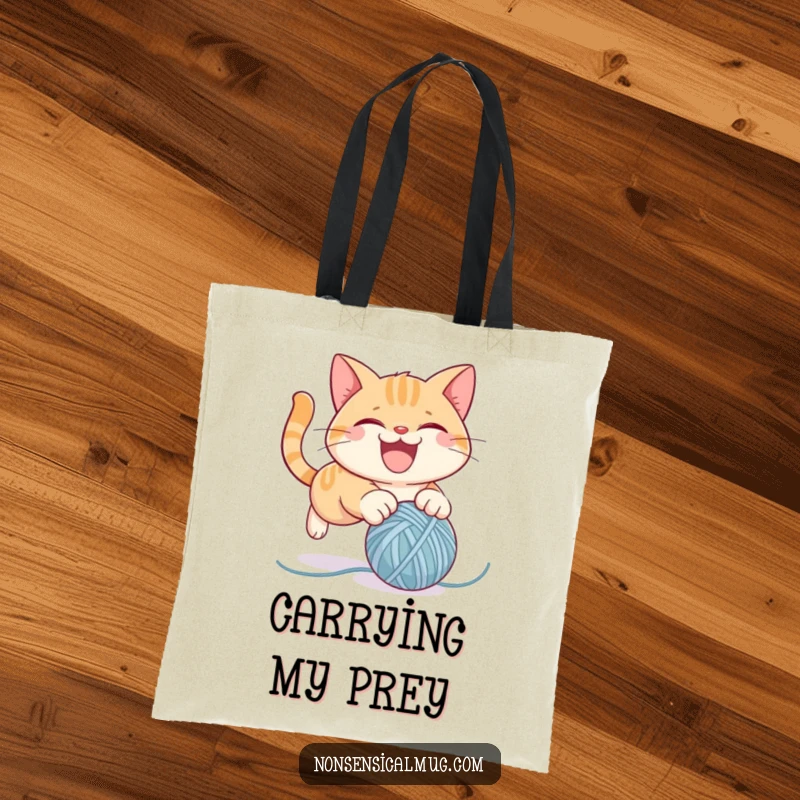 Funny tote bag featuring a mischievous cat character leaping towards a bouncing ball of yarn, combining utility and humor.