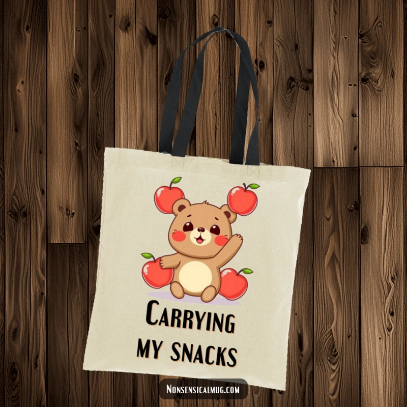 Funny tote bag with a cute, round bear character humorously juggling three shiny apples, ideal for shopping and daily use.